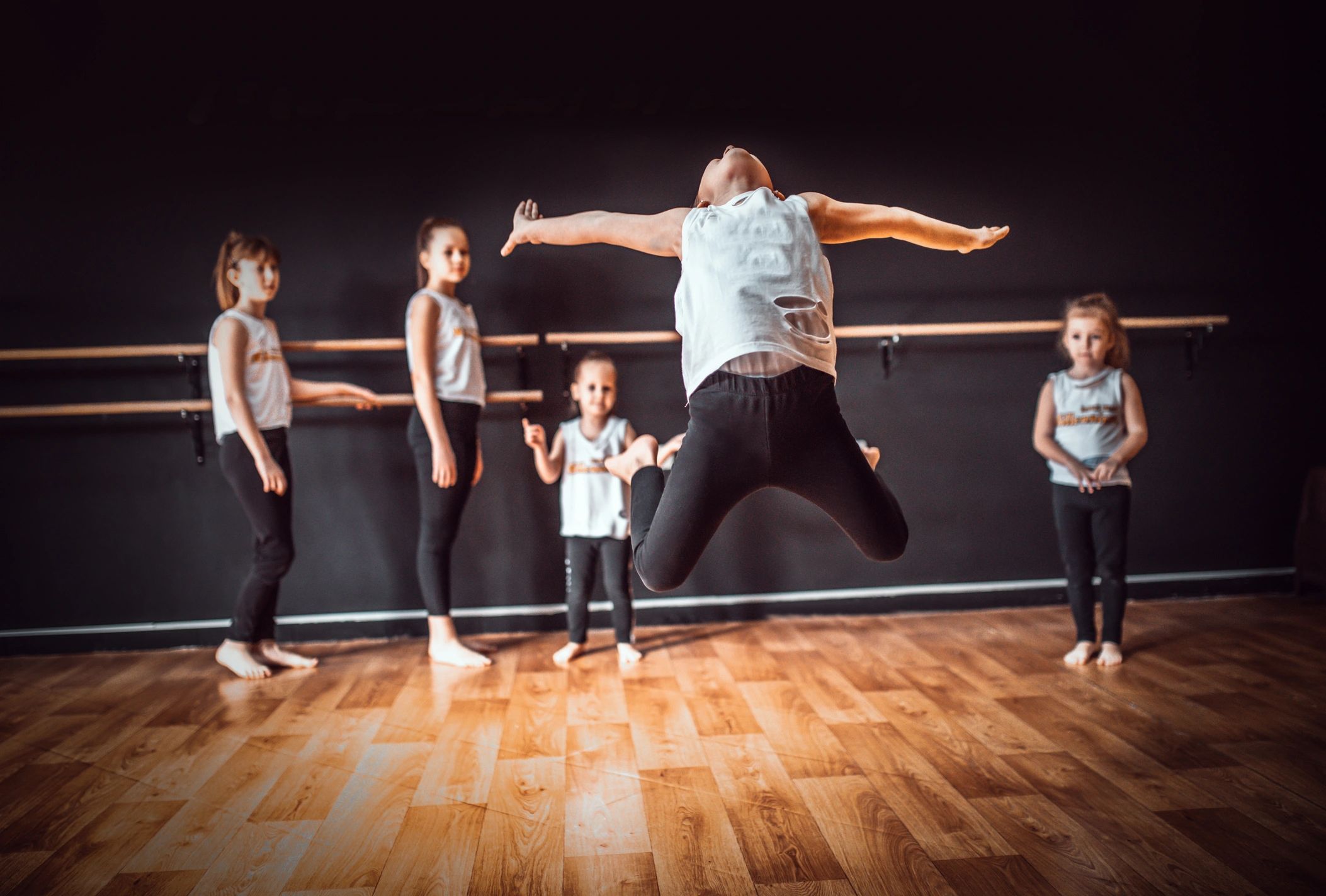 Teacher and group of children exercising dancing and ballet in dance school