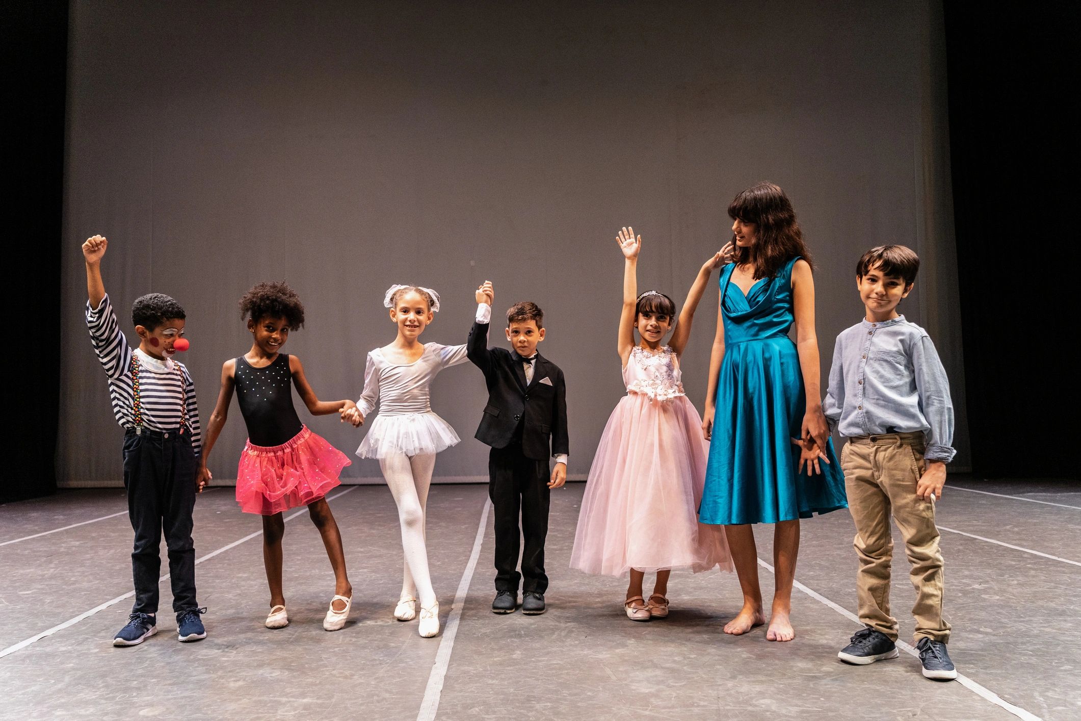 Children performing on stage in a theater setting
