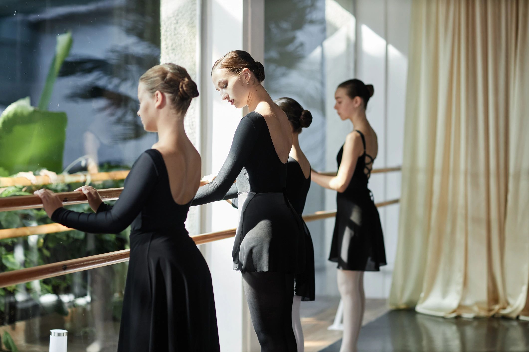 Professional Female Dancer Teaching Teenage Girls Ballet Moves during Class Indoors